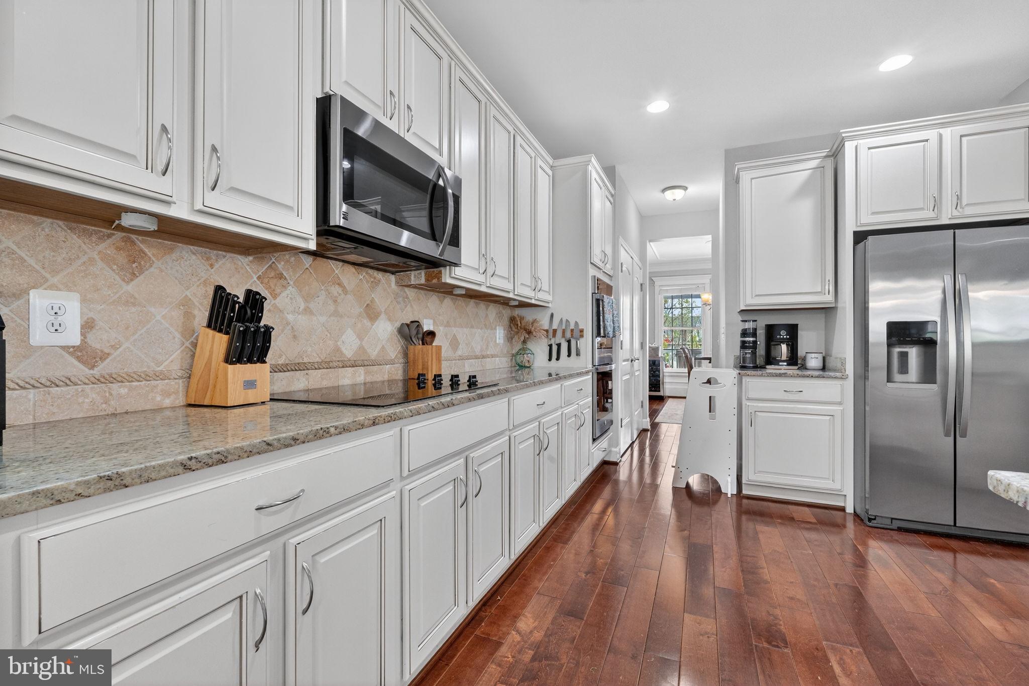 3112 Spring Drive Alexandria, VA 22306 - Photo 19 of 58 a kitchen with stainless steel appliances granite countertop a refrigerator a sink dishwasher a microwave oven and white cabinets with wooden floor