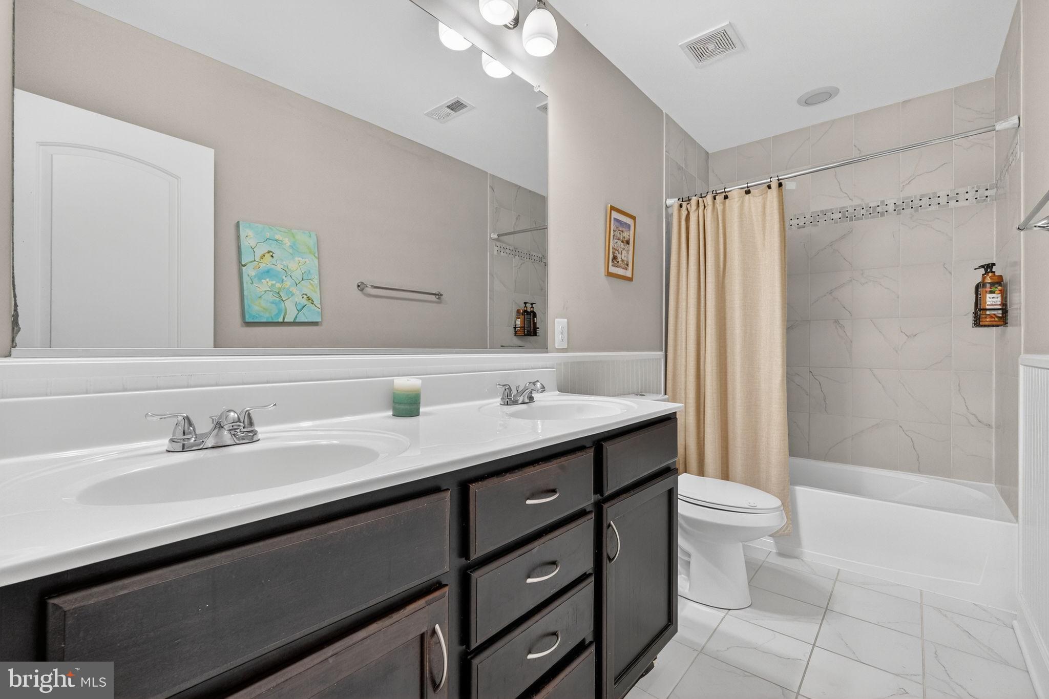 3112 Spring Drive Alexandria, VA 22306 - Photo 33 of 58 a bathroom with a double vanity sink toilet mirror and shower