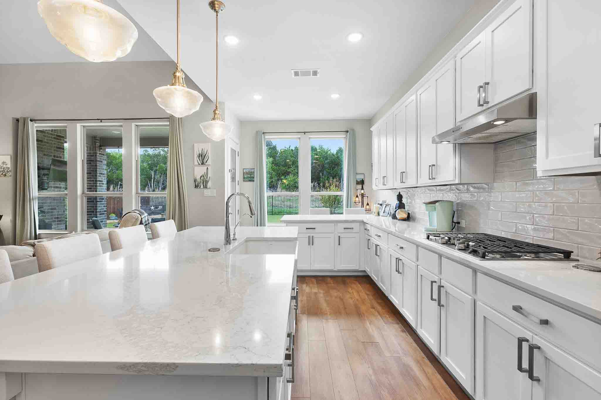 7717 Pace Ravine Drive Lago Vista, TX 78645 - Photo 11 of 39 a large white kitchen with wooden floors and a large window