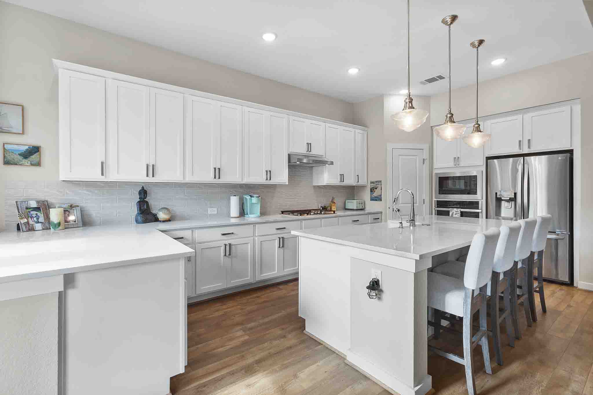 7717 Pace Ravine Drive Lago Vista, TX 78645 - Photo 14 of 39 a kitchen with white cabinets and stainless steel appliances