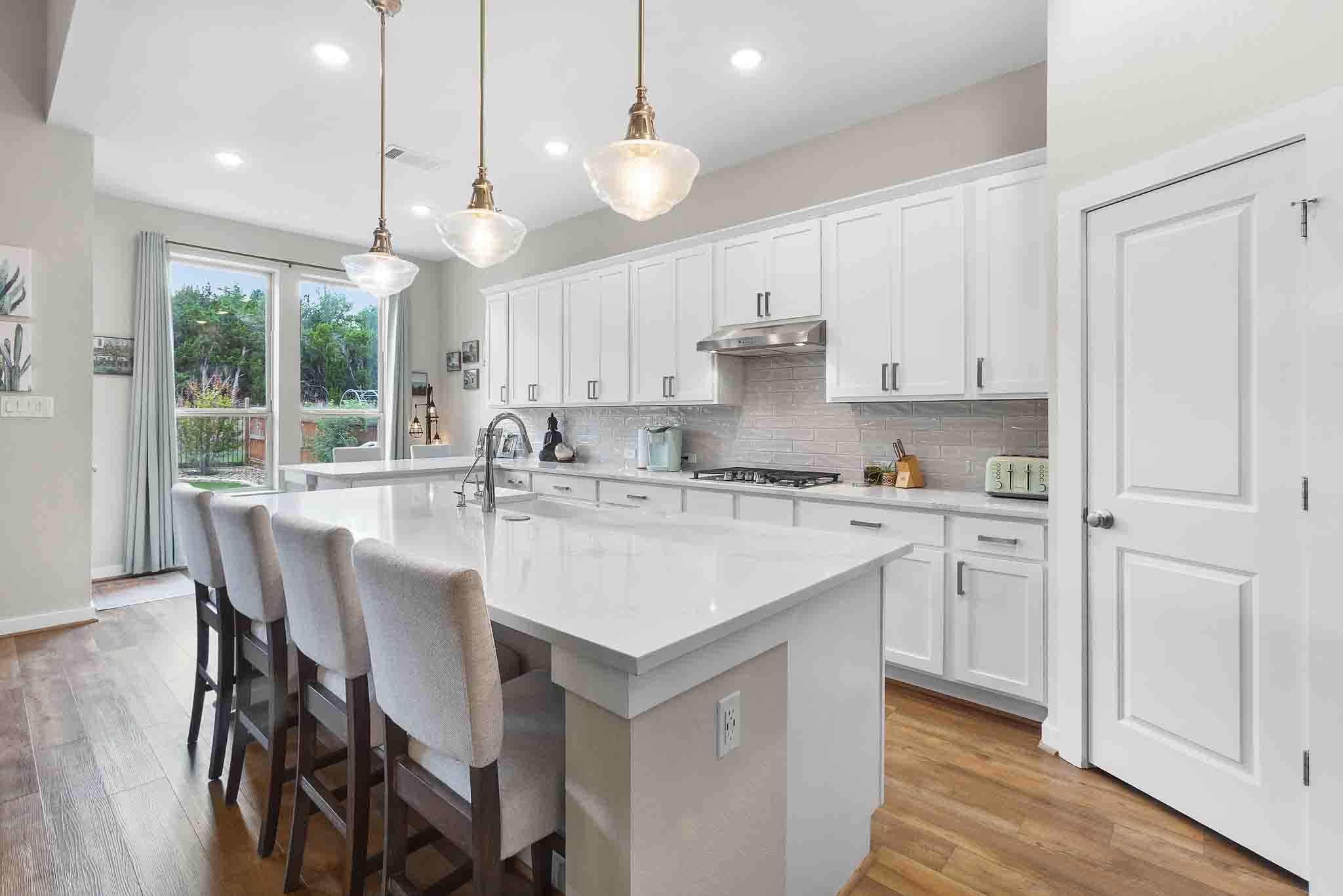 7717 Pace Ravine Drive Lago Vista, TX 78645 - Photo 10 of 39 a kitchen with kitchen island granite countertop a sink a center island and cabinets