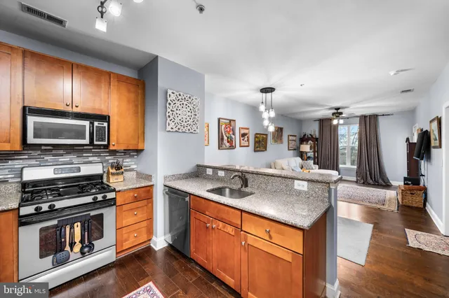 a kitchen with stainless steel appliances granite countertop a sink stove and microwave