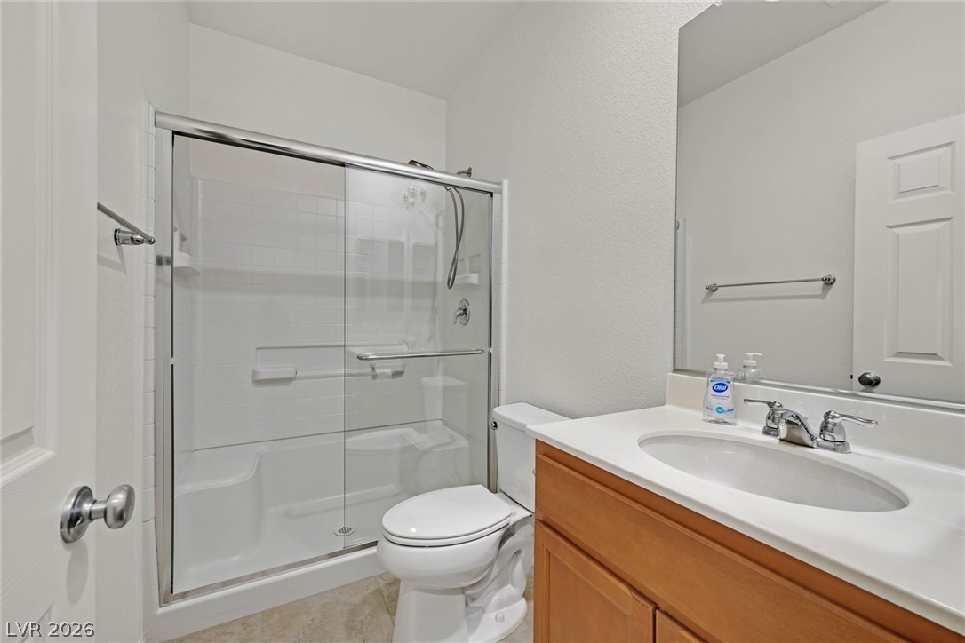 155 Fulgora Street Henderson, NV 89074 - Photo 20 of 30 A pristine bathroom featuring a clear glass shower and functional vanity, ready for daily routines.