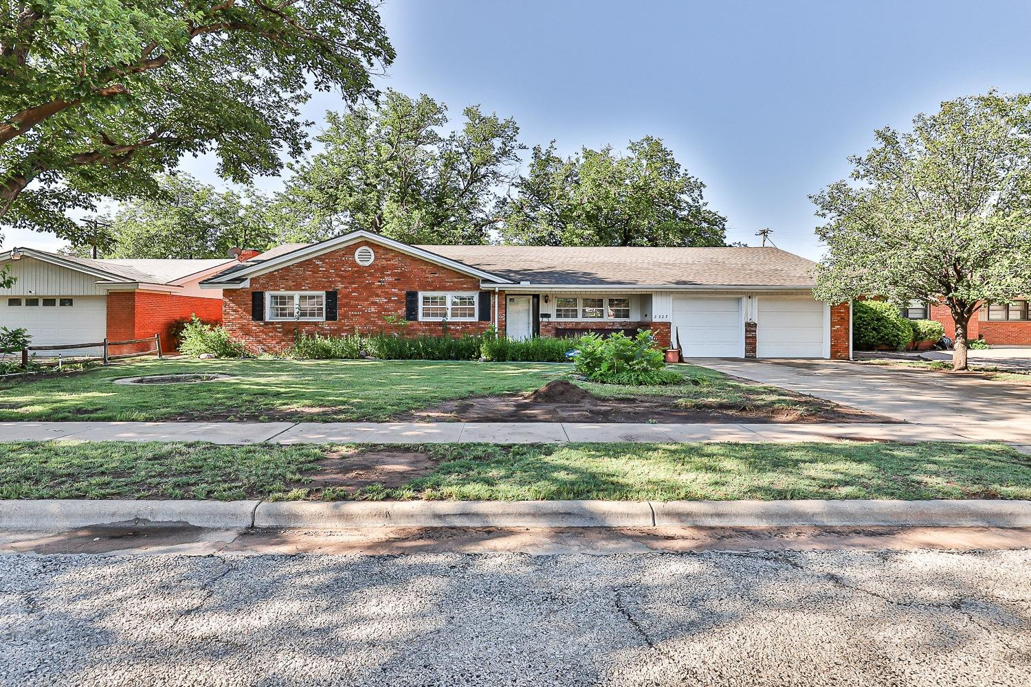 a front view of a house with a yard and a garage