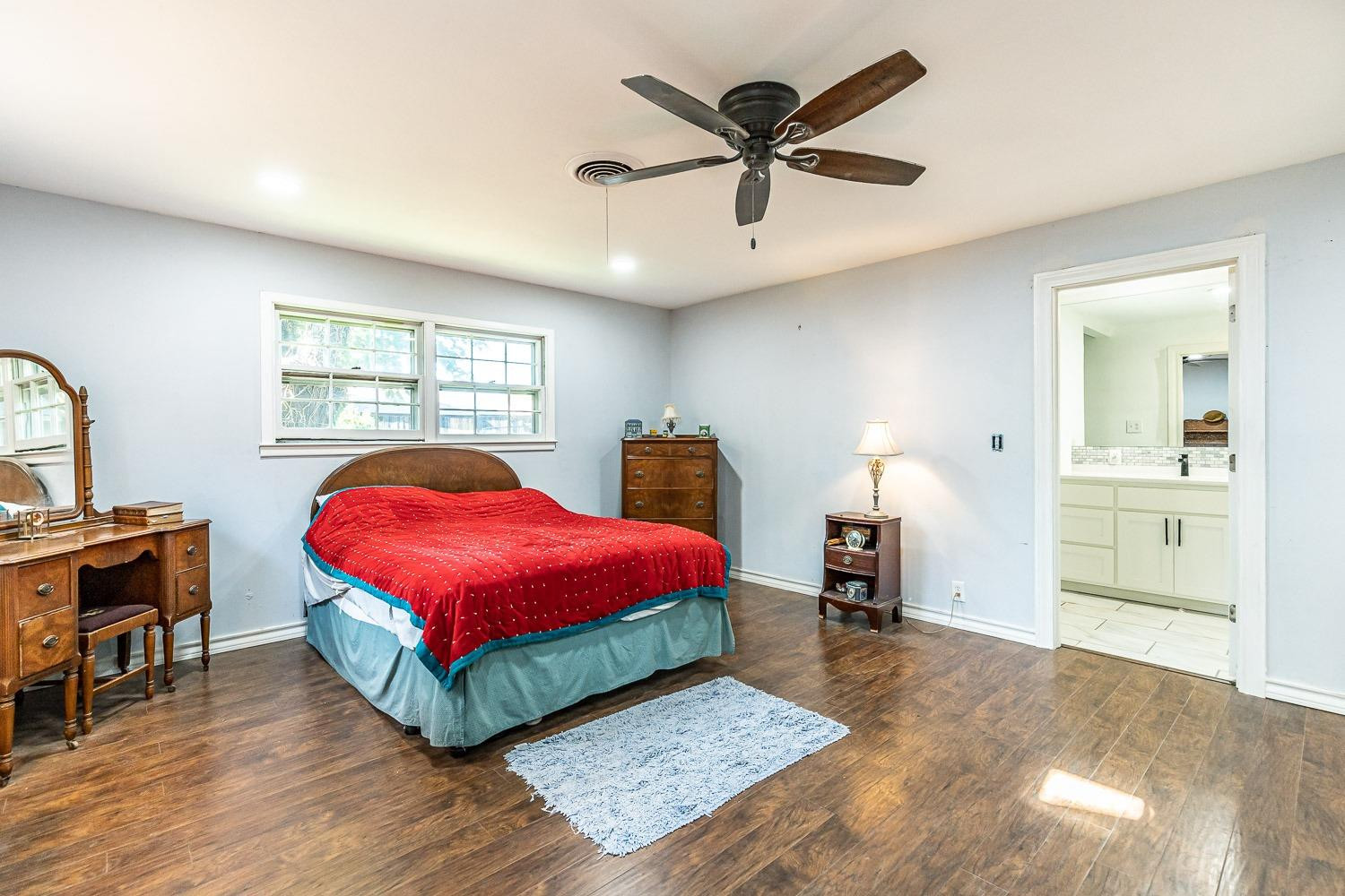 2327 60th Street Lubbock, TX 79412 - Photo 19 of 36 a bedroom with a bed and a chandelier