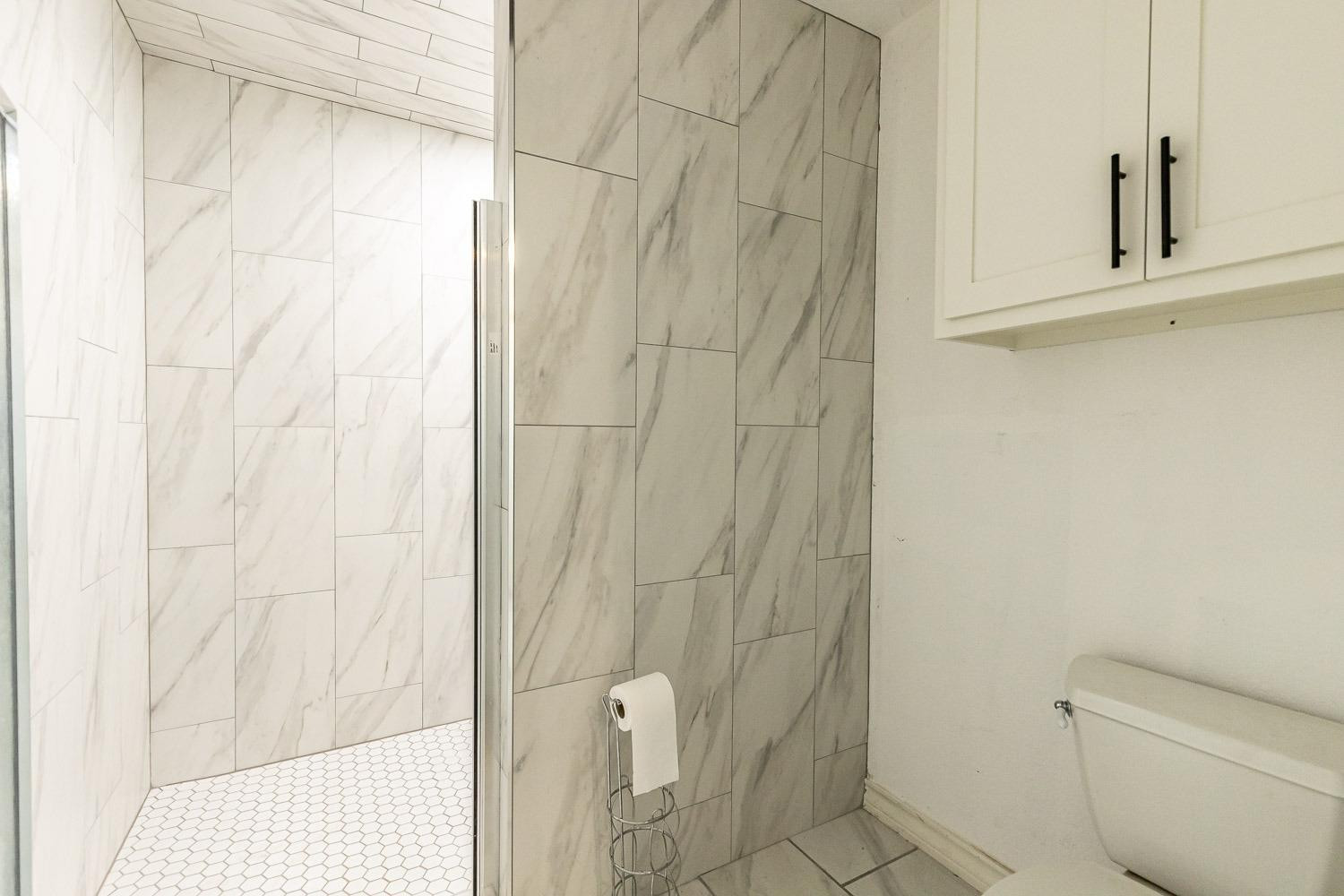 2327 60th Street Lubbock, TX 79412 - Photo 22 of 36 a bathroom with a shower curtain and a toilet