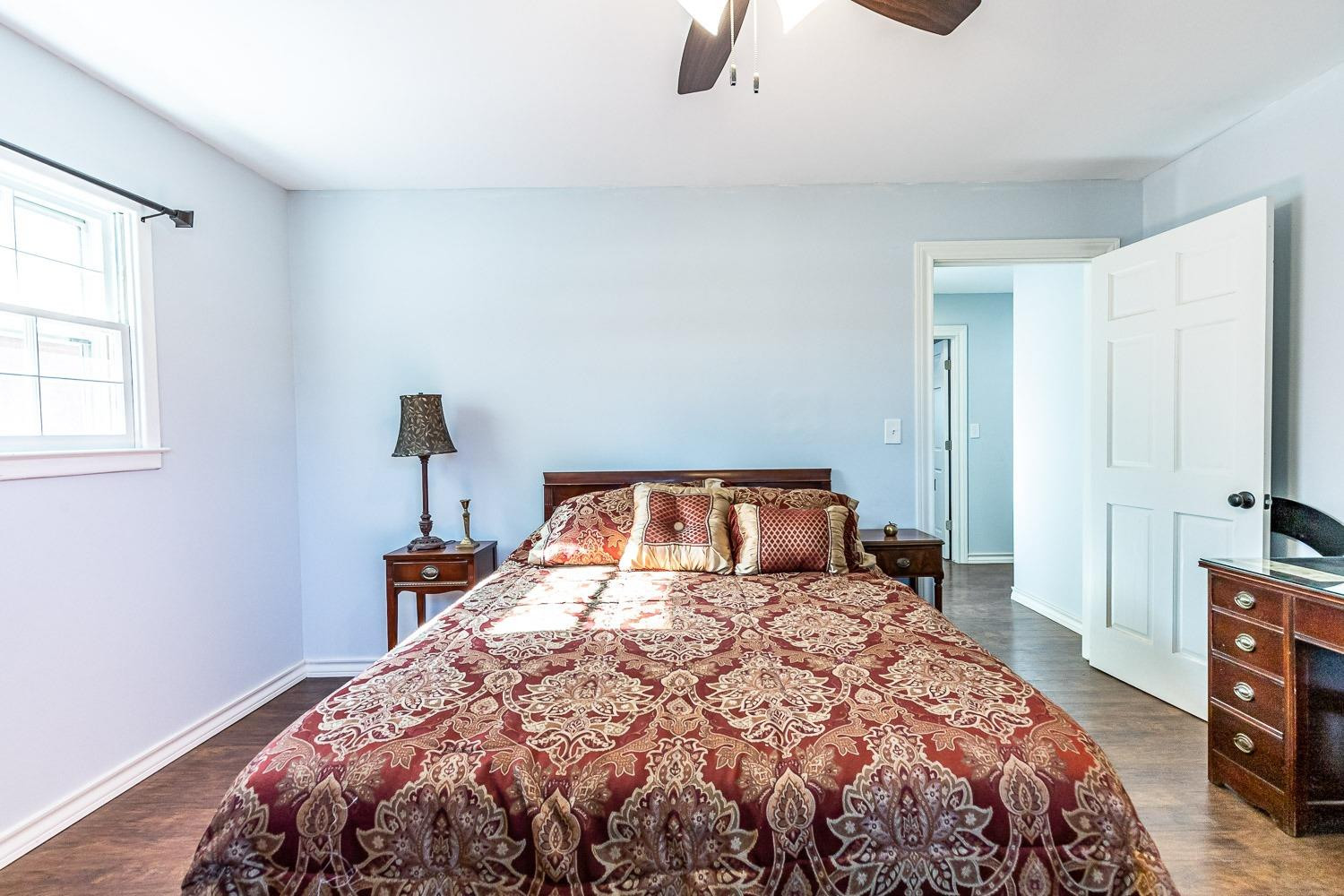 2327 60th Street Lubbock, TX 79412 - Photo 25 of 36 a bedroom with a bed and a lamp