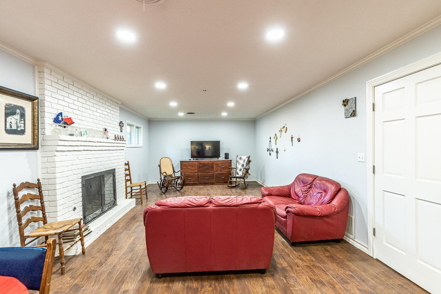 2327 60th Street Lubbock, TX 79412 - Photo 7 of 36 a living room with furniture fireplace and wooden floor