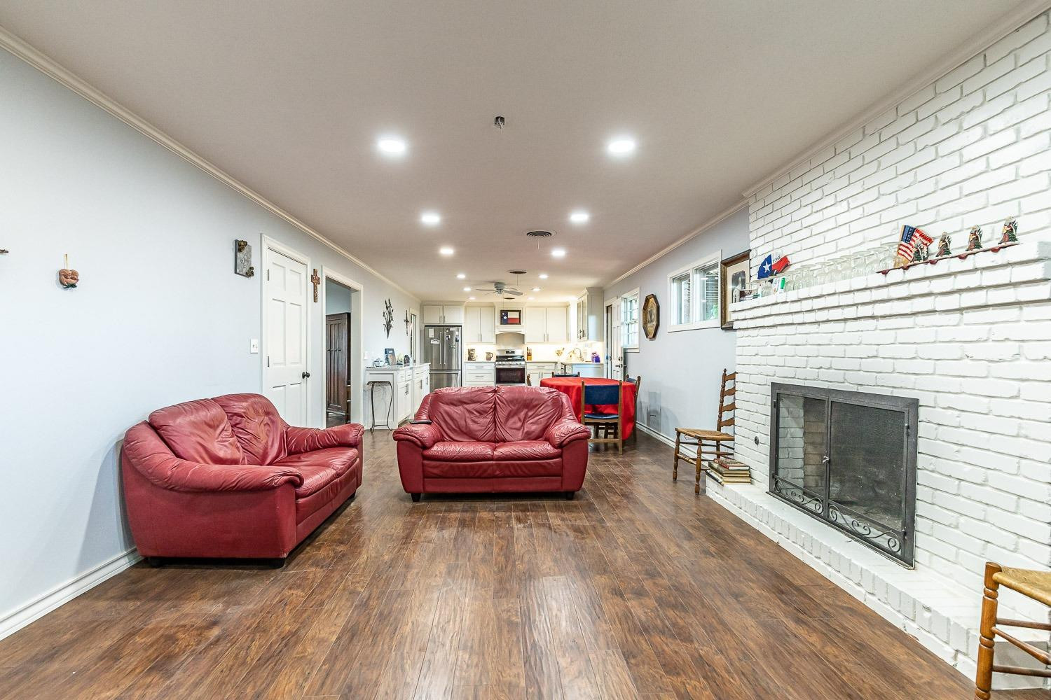 2327 60th Street Lubbock, TX 79412 - Photo 9 of 36 a living room with furniture a fireplace and a wooden floor