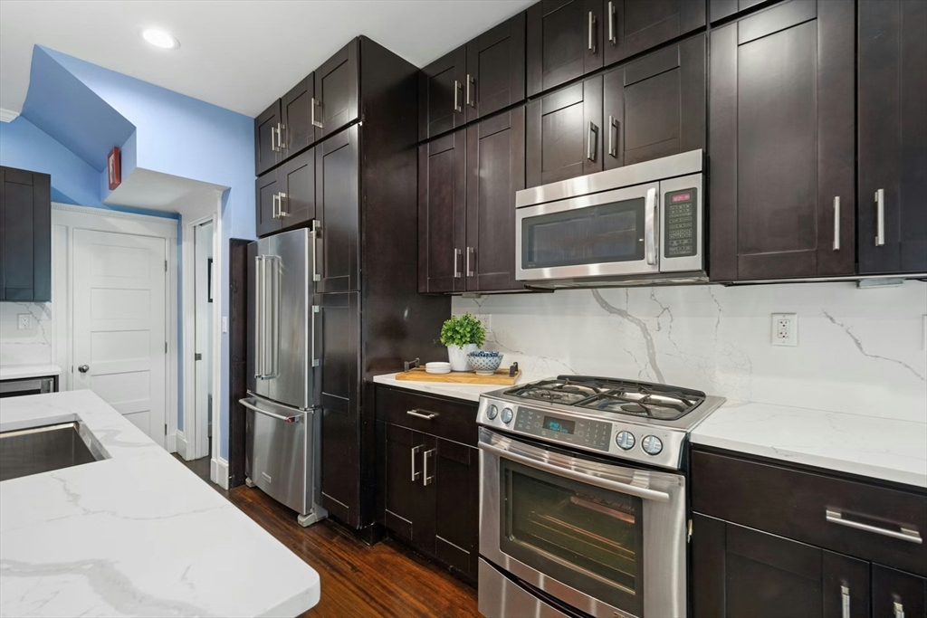 15 Oakview Terrace, Unit 2 Boston, MA 02130 - Photo 3 of 29 a kitchen with stainless steel appliances a stove a sink and a microwave