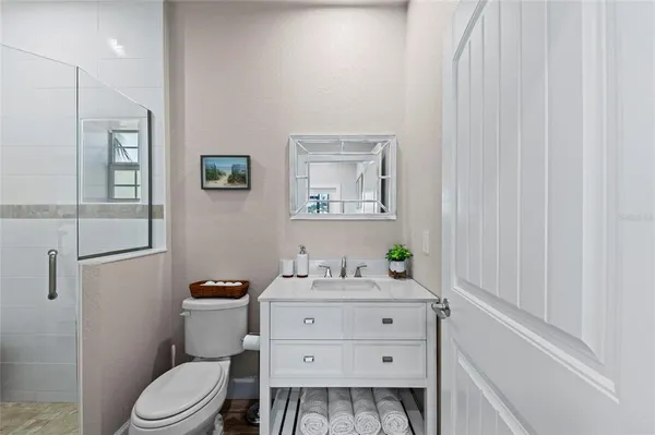 a bathroom with a sink a toilet and shower