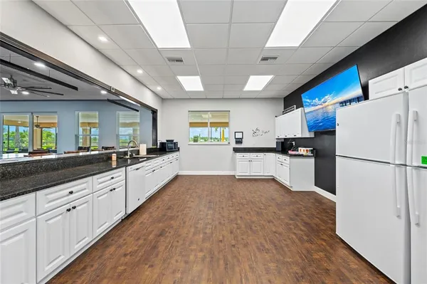 a large kitchen with stainless steel appliances kitchen island a large counter top a sink a stove and a refrigerator
