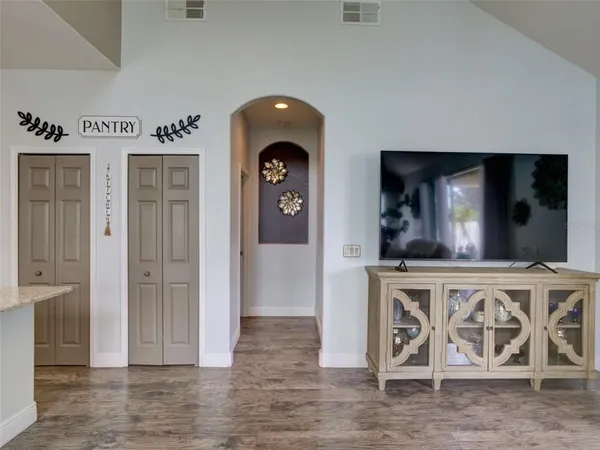 an entryway view with wooden floor table and chairs