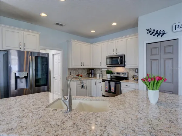 a kitchen with stainless steel appliances kitchen island granite countertop a refrigerator and a stove top oven