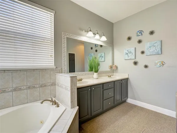 a bathroom with a tub a sink and mirror