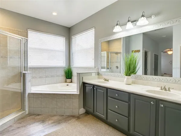 a bathroom with a double vanity sink mirror and bathtub