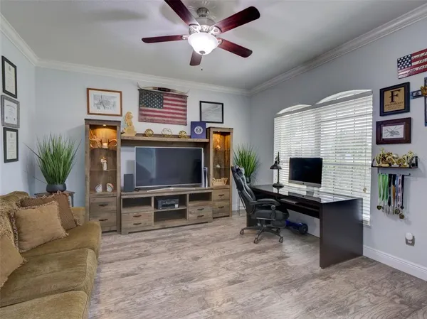 a living room with furniture a flat screen tv and a window