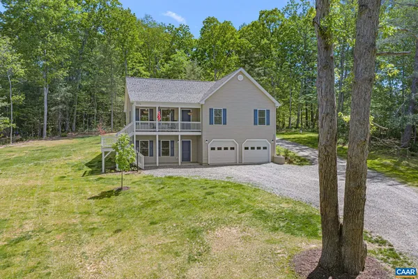 a view of a house with backyard and a tree