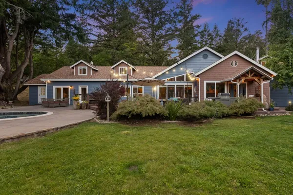 a front view of a house with a garden and trees