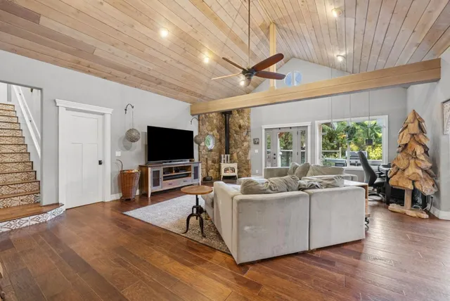 a large kitchen with stainless steel appliances granite countertop a stove and a view of living room