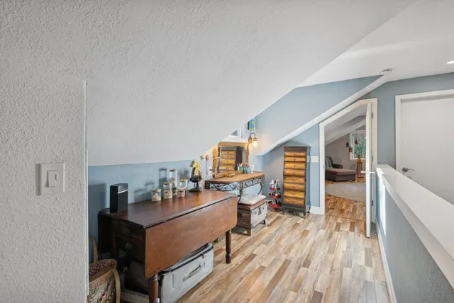 a view of a patio with table and chairs and a barbeque with potted plants and large trees