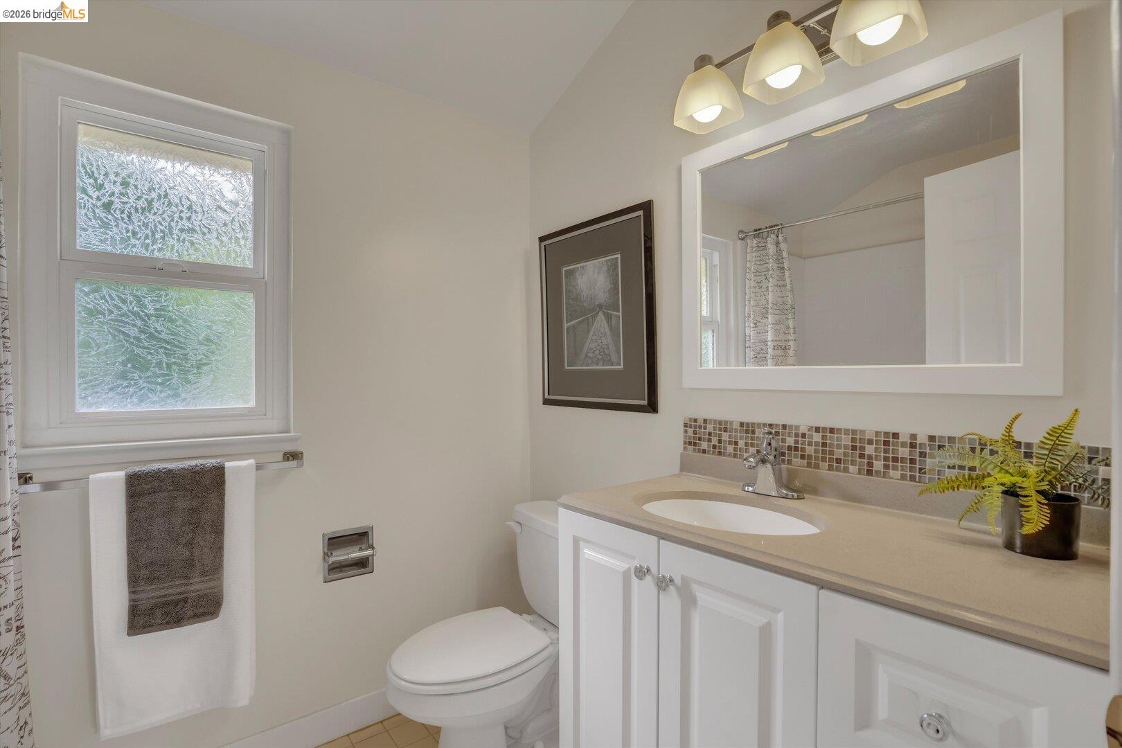 1878 Polk Street Concord, CA 94521 - Photo 17 of 40 a bathroom with a granite countertop sink a toilet and a mirror