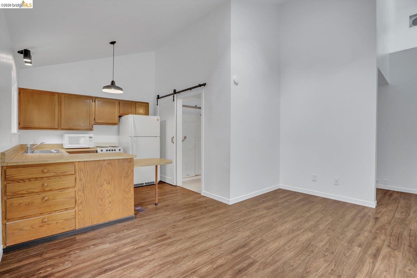 1878 Polk Street Concord, CA 94521 - Photo 23 of 40 a kitchen with wooden floors and white cabinets