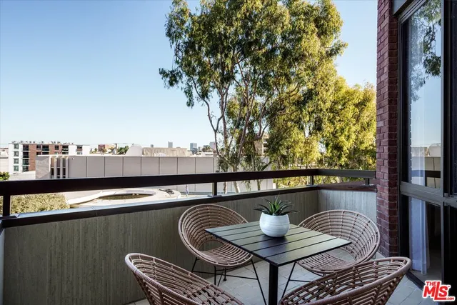 a view of a balcony with two chairs and a potted plant