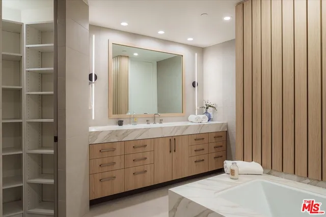 a spacious bathroom with a double vanity sink a mirror and a bathtub