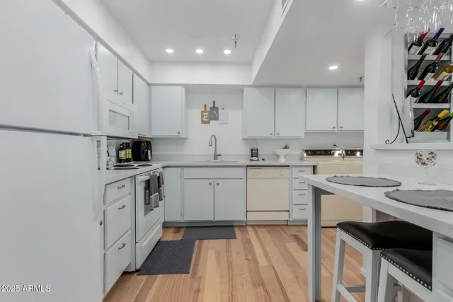 a kitchen with white cabinets appliances and a sink