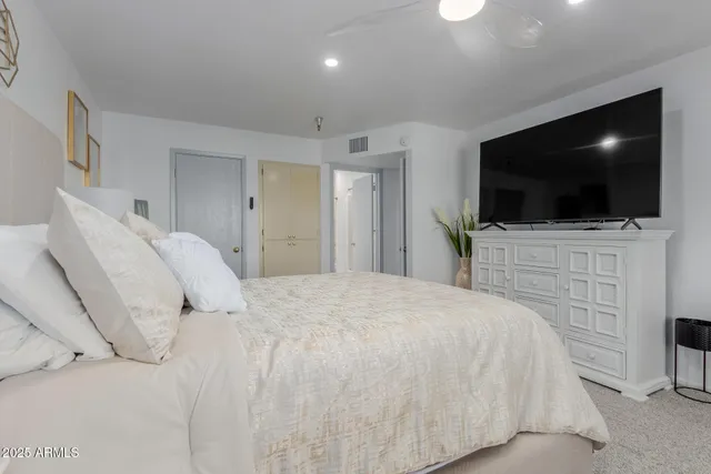 a bedroom with a bed and a flat screen tv