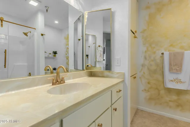 a bathroom with a sink shower and a mirror