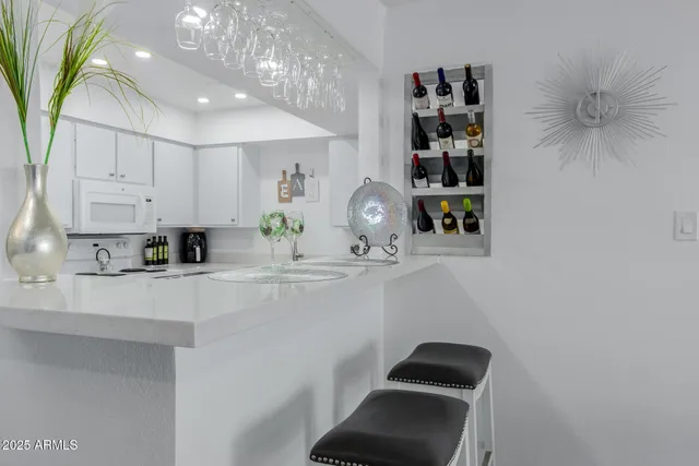 a kitchen with stainless steel appliances a sink a stove a refrigerator cabinets and a dining table