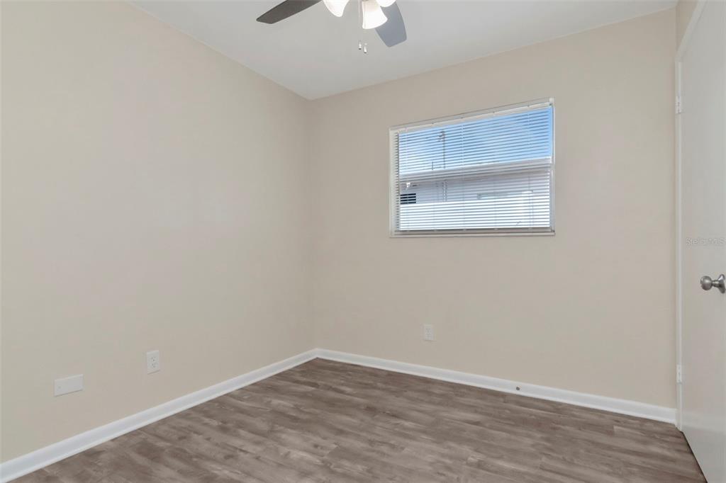 126 Kingsway Road Brandon, FL 33510 - Photo 25 of 42 an empty room with a chandelier fan and wooden floor