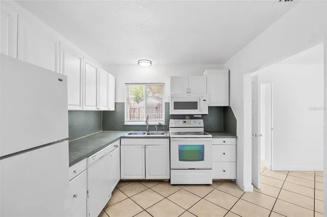 a view of an empty room and window chandelier fan