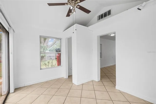 an empty room with windows and fan