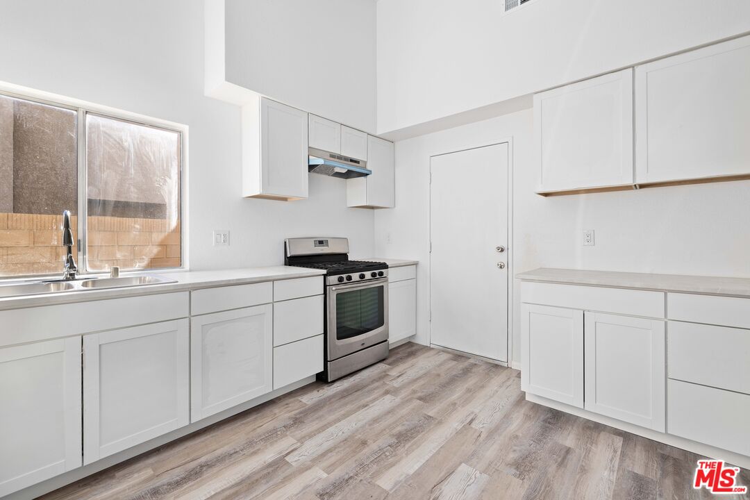1415 Kings Road Palmdale, CA 93551 - Photo 12 of 27 a kitchen with white cabinets and white appliances