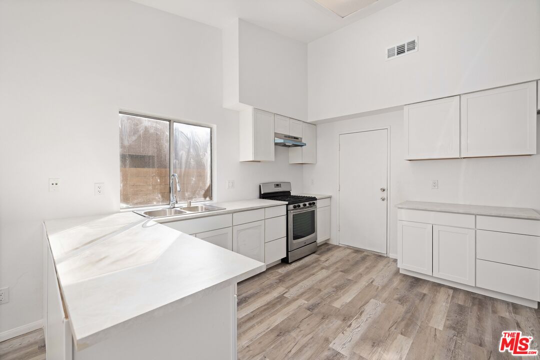 1415 Kings Road Palmdale, CA 93551 - Photo 8 of 27 a kitchen with granite countertop white cabinets and white appliances