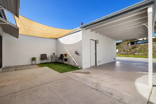 an aerial view of residential house with outdoor space and trees all around