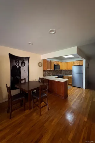 a open kitchen with stainless steel appliances kitchen island granite countertop a table and chairs in it