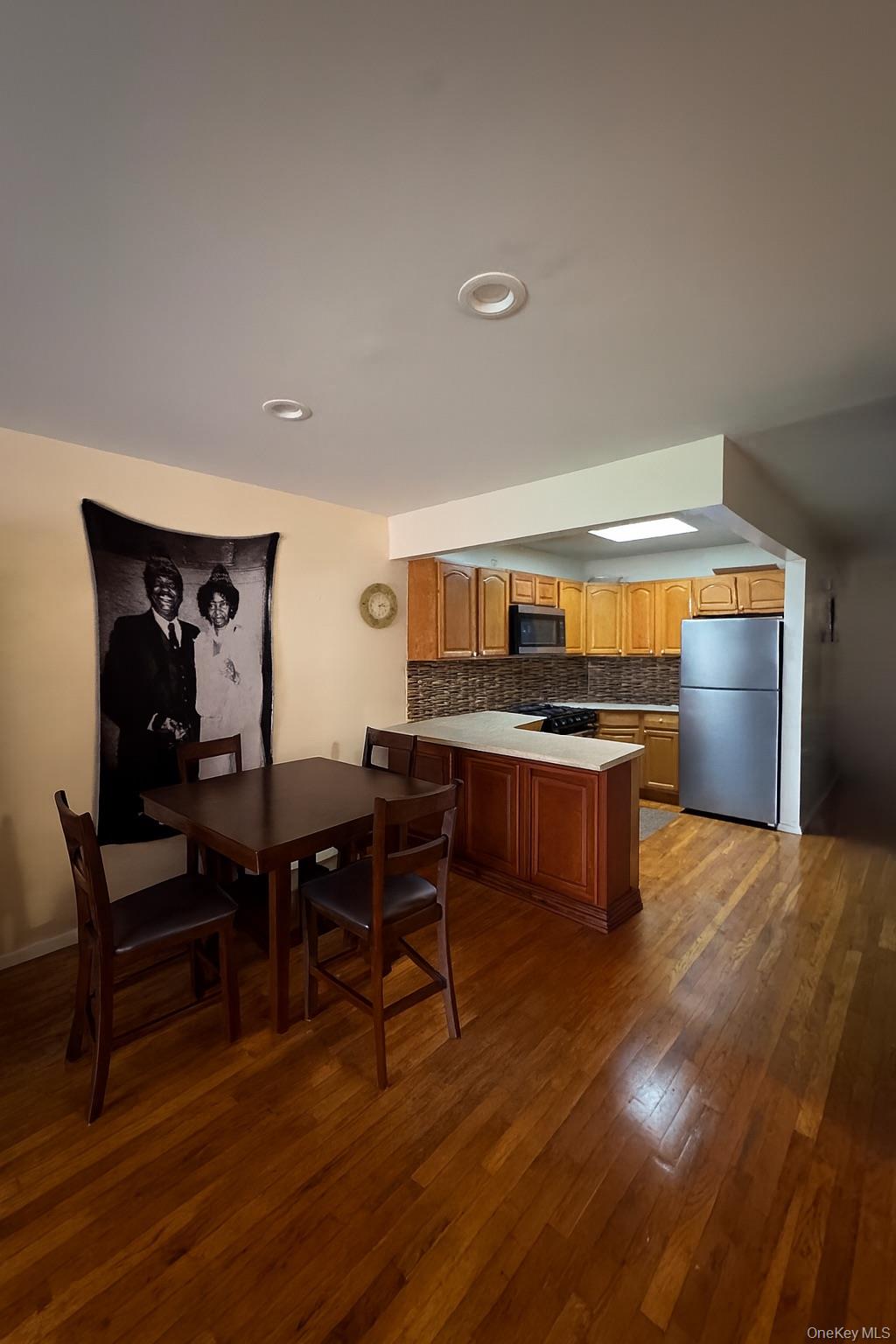 472 Sutter Avenue Brooklyn, NY 11207 - Photo 3 of 8 a open kitchen with stainless steel appliances kitchen island granite countertop a table and chairs in it