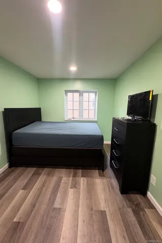 a bedroom with a bed window and a dresser