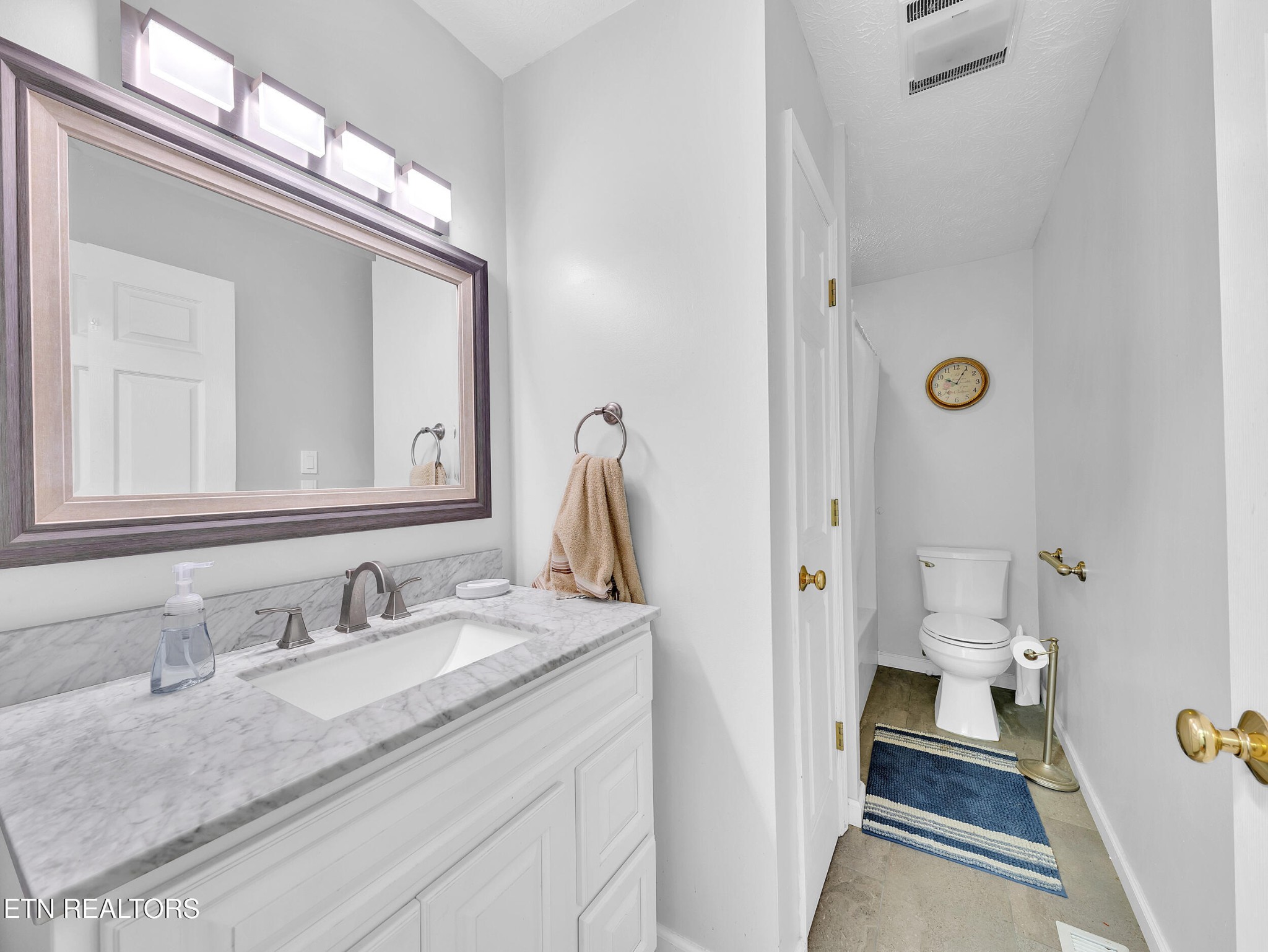 3342 Shagbark Road Powell, TN 37849 - Photo 12 of 32 a bathroom with a granite countertop sink a mirror and a toilet