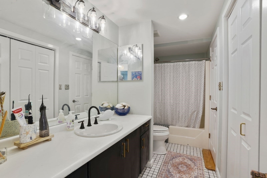 1 Commodore Court, Unit 104 Hull, MA 02045 - Photo 23 of 35 a bathroom with a sink double vanity and a mirror
