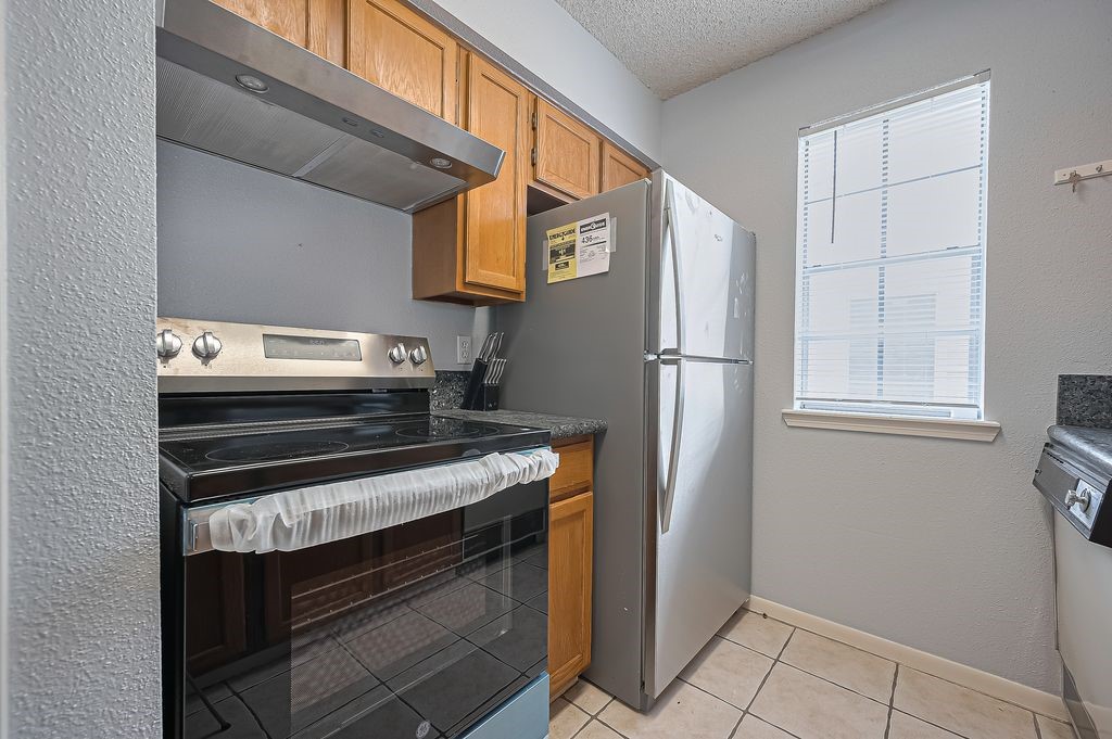 3100 Jeanetta Street, Unit 1104 Houston, TX 77063 - Photo 12 of 25 a kitchen with a stove and a refrigerator