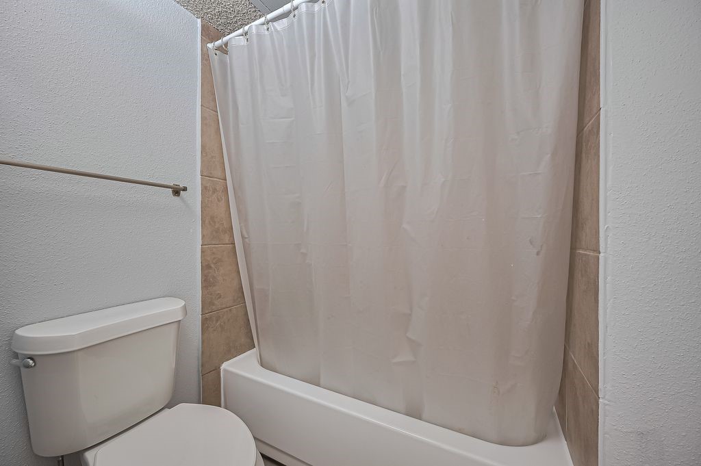 3100 Jeanetta Street, Unit 1104 Houston, TX 77063 - Photo 19 of 25 a white toilet sitting next to a shower