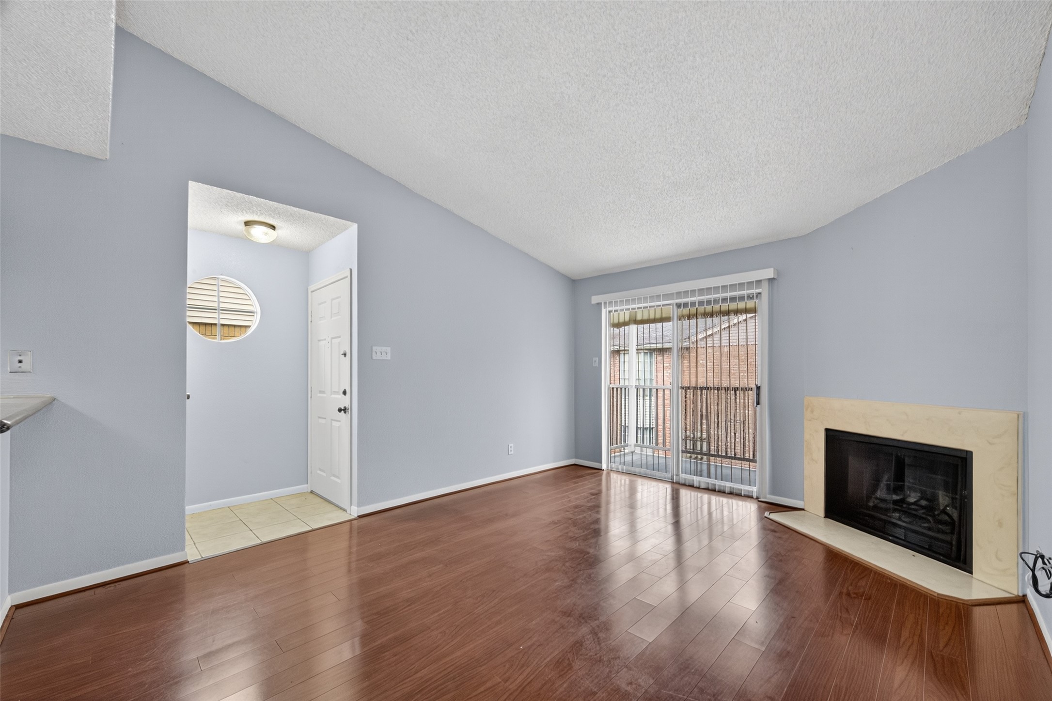 3100 Jeanetta Street, Unit 1104 Houston, TX 77063 - Photo 8 of 25 an empty room with wooden floor a fireplace and windows