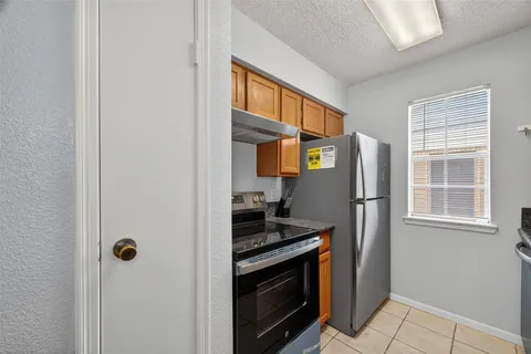 an empty room with wooden floor a fireplace and windows