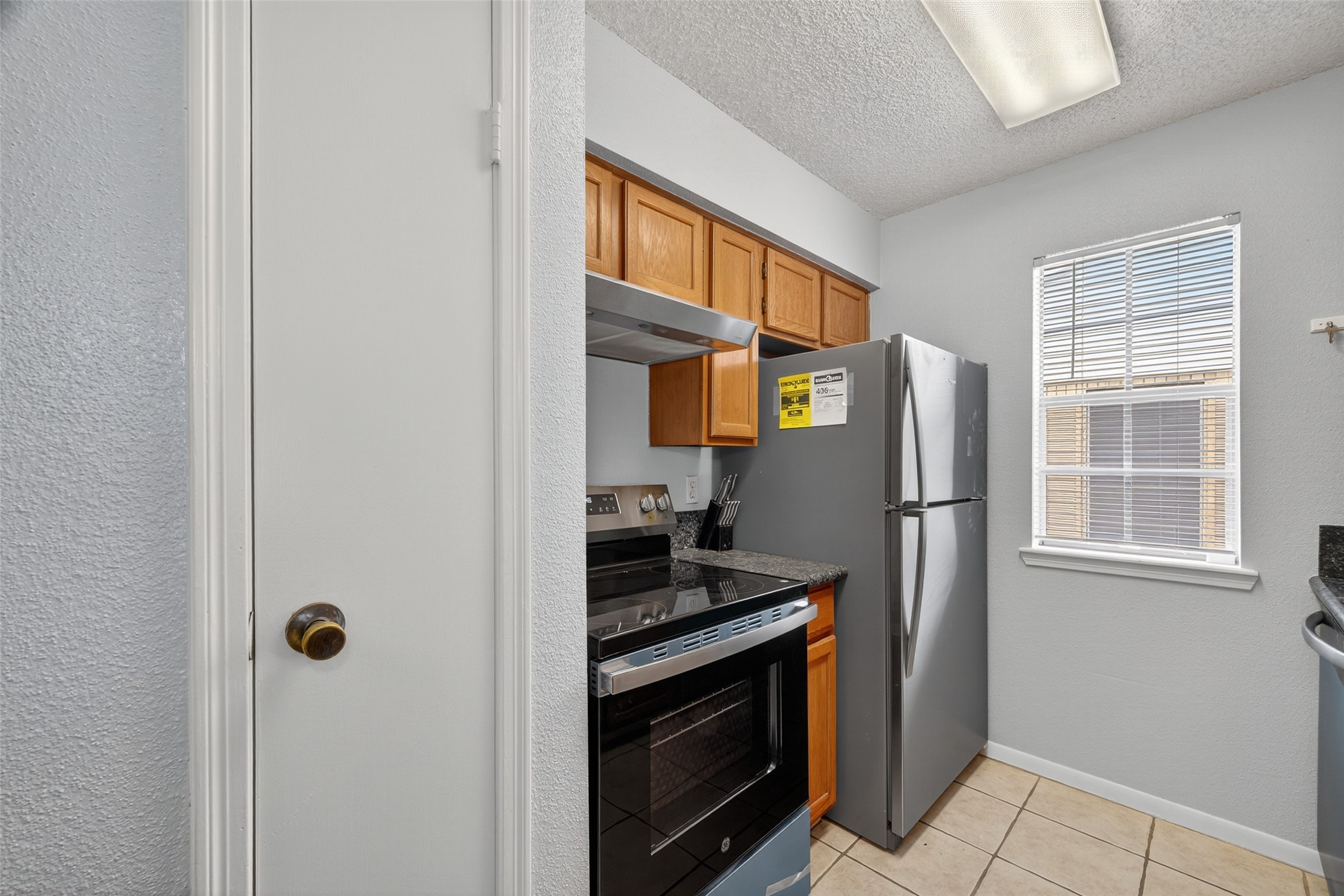 3100 Jeanetta Street, Unit 1104 Houston, TX 77063 - Photo 9 of 25 a kitchen with stainless steel appliances granite countertop a refrigerator and a stove