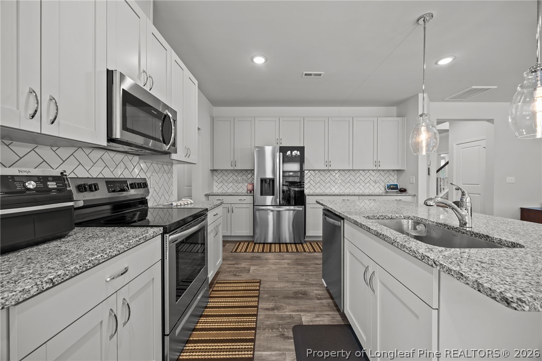 334 Beacon Hl Road Lillington, NC 27546 - Photo 13 of 49 a kitchen with stainless steel appliances granite countertop a sink stove and microwave